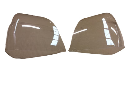 Two clear plastic car headlight covers on a brown background